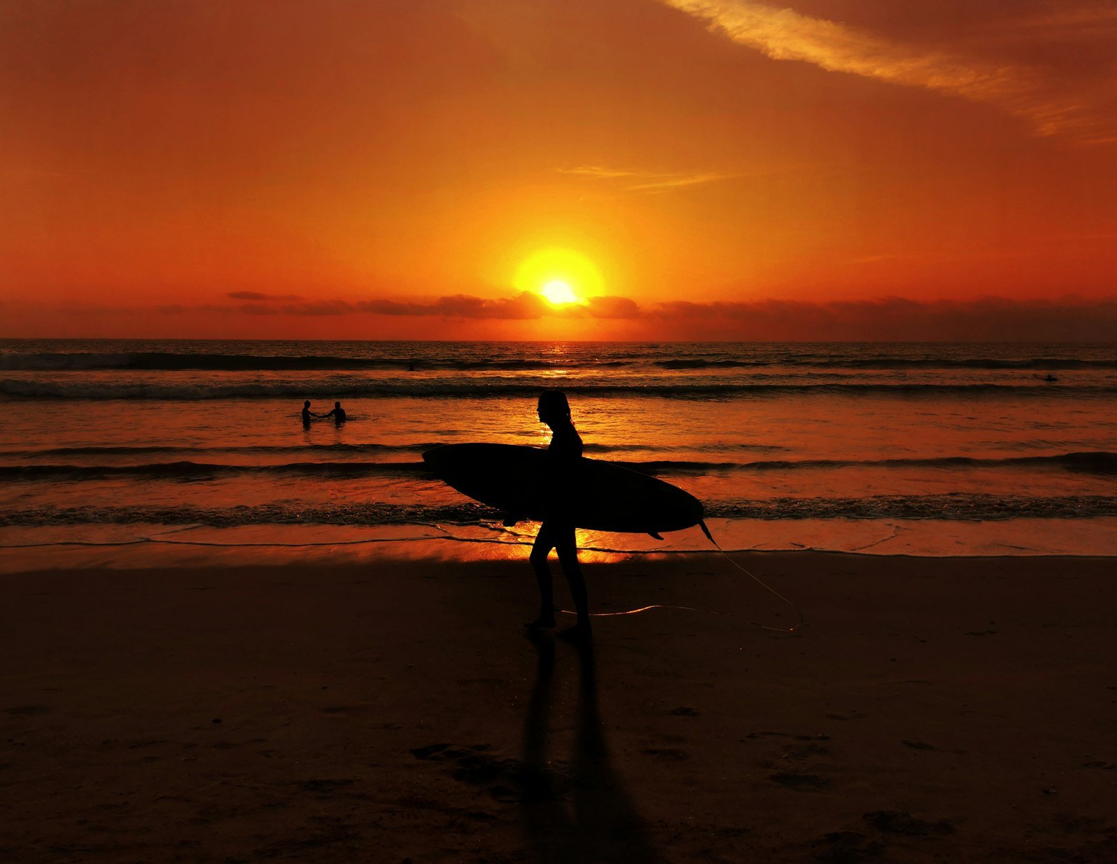 Surfer at sunset on a Bali beach